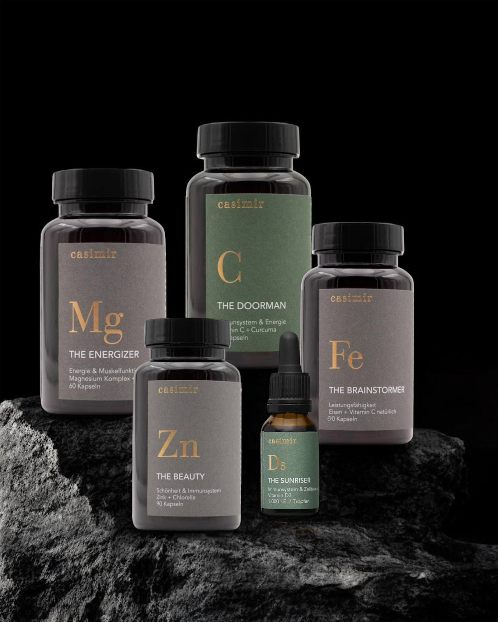 Mehrere Vitamin- und Mineralstoff-Flaschen in dunklem, ästhetischem Setting vor schwarzem Hintergrund. Fitaura