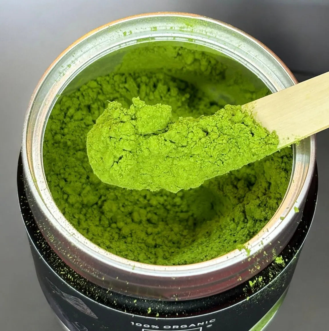 Leuchtend grünes matcha pulver auf Holzspatel, Nahaufnahme